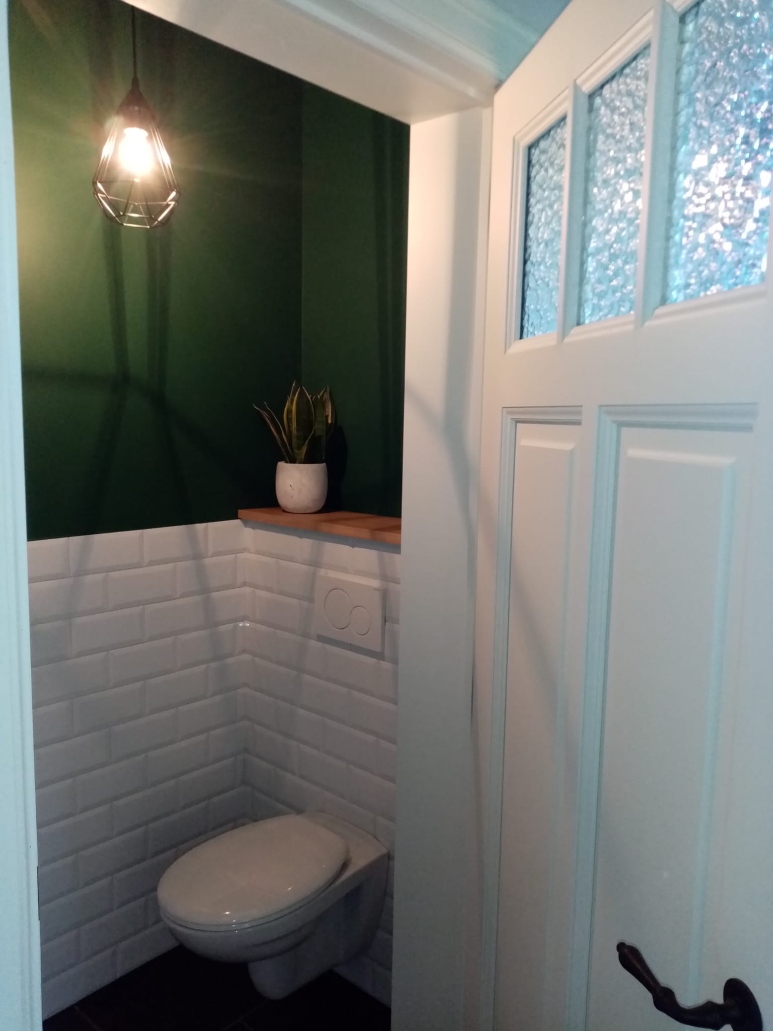 Juist afgewekt toilet met tegels aan de muur